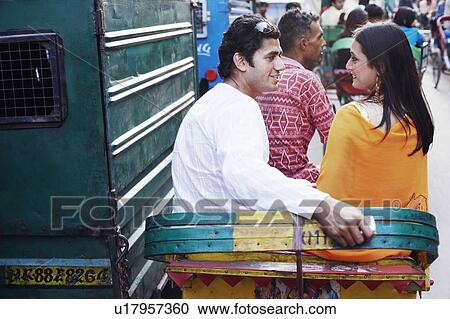 Rear view of a young couple sitting in a rickshaw View Large Photo Image Stock Image - Rear view of a young couple sitting in a rickshaw. Fotosearch