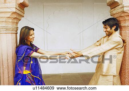 Stock Photo - Side profile of a young couple holding hands. Fotosearch