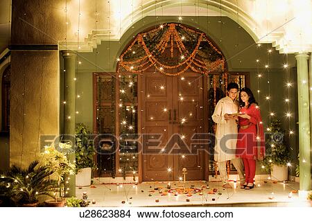 Young couple holding oil lamps in a plate View Large Photo Image Picture - Young couple holding oil lamps in a plate. Fotosearch