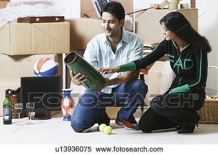 Stock Photography - Young couple looking at a vase. Fotosearch