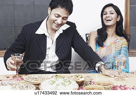 Young couple sitting at the dining table View Large Photo Image Stock Image - Young couple sitting at the dining table. Fotosearch