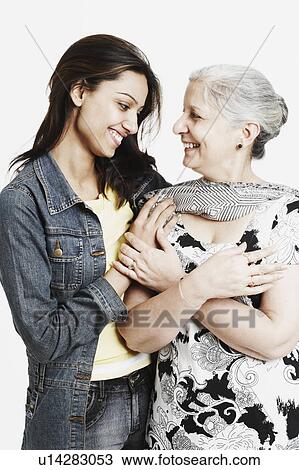 Stock Image - Close-up of a mature woman and her granddaughter looking at each other. Fotosearch
