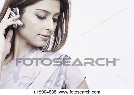 Stock Photo - Close-up of a young woman wearing a hands free device. Fotosearch