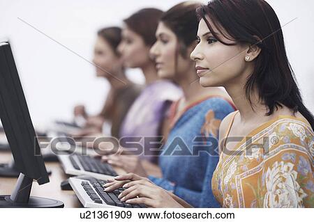 Close-up of four businesswomen sitting in front of computers View Large Photo Image Stock Photo - Close-up of four businesswomen sitting in front of computers. Fotosearch