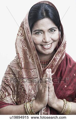 Stock Photography - Portrait of a mature woman greeting with her hands together. Fotosearch