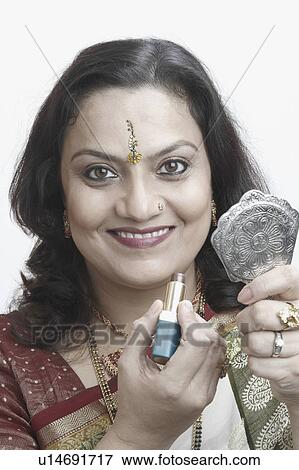 Portrait of a mature woman holding a lipstick and a mirror View Large Photo Image Stock Photo - Portrait of a mature woman holding a lipstick and a mirror. Fotosearch