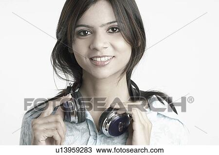 Portrait of a young woman with headphones around her neck View Large Photo Image Stock Image - Portrait of a young woman with headphones around her neck. Fotosearch