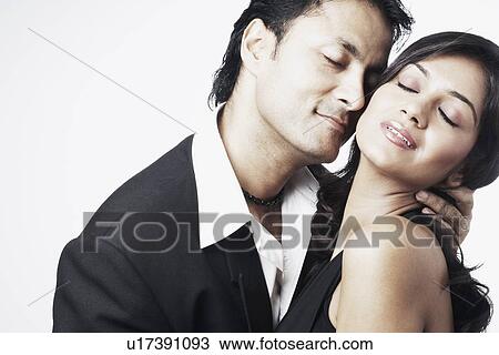 Stock Image - Young man embracing a young woman. Fotosearch