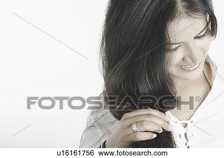 Young woman holding her hair View Large Photo Image Stock Photograph - Young woman holding her hair. Fotosearch