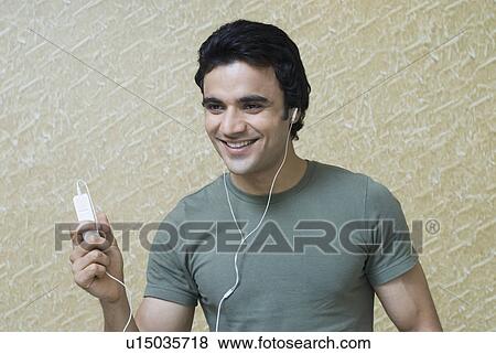 Stock Photo - Close-up of a young man listening to an MP3 player. Fotosearch