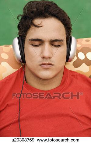 Stock Photo - Close-up of a young man listening to music. Fotosearch