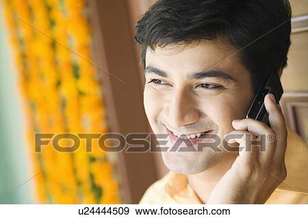 Stock Photo - Close-up of a young man talking on a mobile phone. Fotosearch