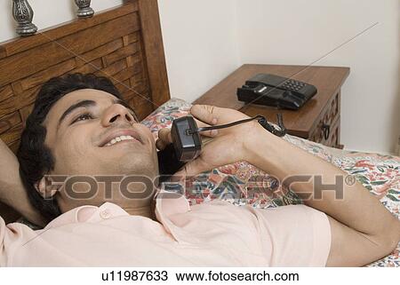 Close-up of a young man talking on the telephone View Large Photo Image Stock Image - Close-up of a young man talking on the telephone. Fotosearch
