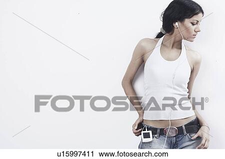 Stock Image - Close-up of a young woman listening to an MP3 player. Fotosearch