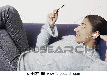 Stock Photography - Close-up of a young woman listening to music. Fotosearch