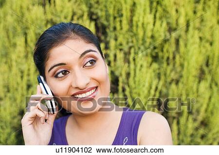 Stock Image - Close-up of a young woman talking on a mobile phone. Fotosearch