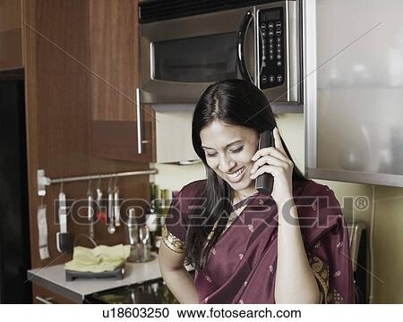 Stock Image - Close-up of a young woman using a mobile phone. Fotosearch