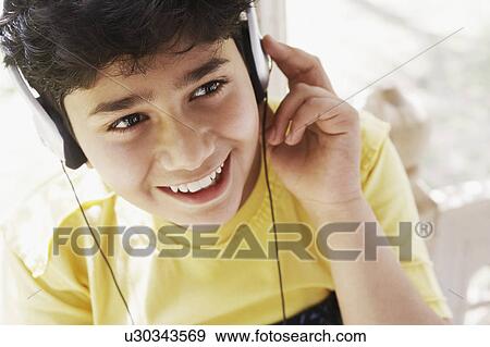 Stock Photo - High angle view of a boy listening to music on headphones. Fotosearch