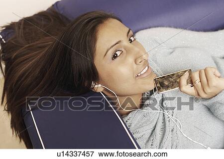 Stock Photo - High angle view of a young woman listening to music. Fotosearch