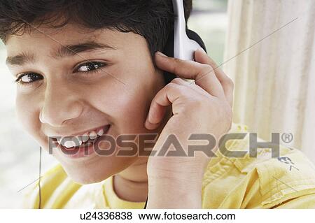 Stock Photo - Portrait of a boy listening to music on headphones. Fotosearch