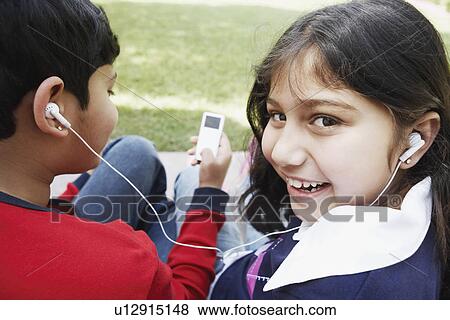 Portrait of a girl and her brother listening to an MP3 player View Large Photo Image Stock Photo - Portrait of a girl and her brother listening to an MP3 player. Fotosearch
