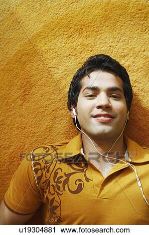 Portrait of a young man wearing headphones and smiling View Large Photo Image Stock Image - Portrait of a young man wearing headphones and smiling. Fotosearch