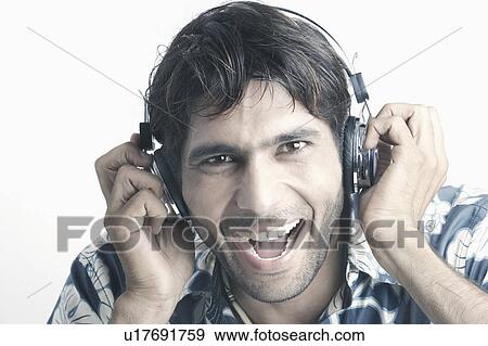 Portrait of a young man wearing headphones listening to music View Large Photo Image Stock Photo - Portrait of a young man wearing headphones listening to music. Fotosearch
