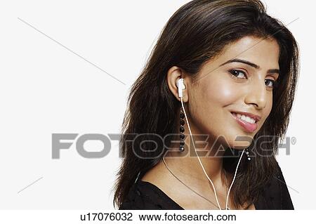 Stock Image - Portrait of a young woman wearing headphones and listening to music. Fotosearch
