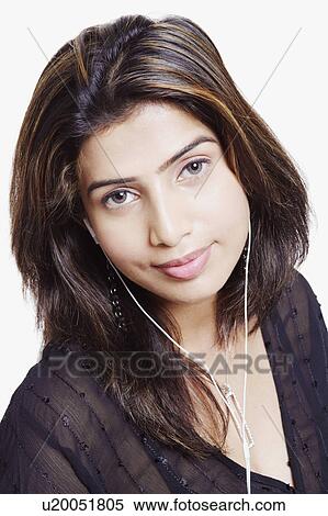 Stock Photography - Portrait of a young woman wearing headphones and listening to music. Fotosearch