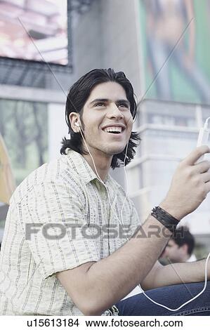 Picture - Side profile of a young man listening to an MP3 player. Fotosearch