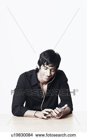 Picture - Young man listening to an MP3 player. Fotosearch