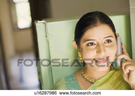 Stock Photograph - Young woman talking on a mobile phone. Fotosearch