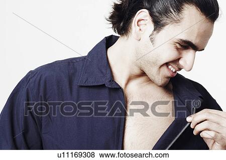 Stock Photo - Close-up of a young man holding his shirt collar. Fotosearch