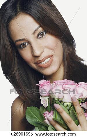 Stock Photography - Portrait of a young woman holding a bouquet of roses and smiling. Fotosearch