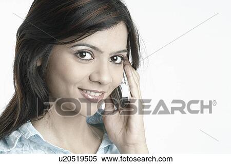 Stock Photography - Portrait of a young woman using a mobile phone. Fotosearch
