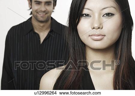 Picture - Portrait of a young woman with a young man standing behind her. Fotosearch