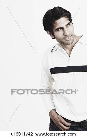Close-up of a young man smiling and looking away View Large Photo Image Stock Image - Close-up of a young man smiling and looking away. Fotosearch