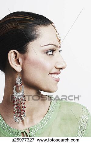 Stock Photo - Close-up of a young woman looking sideways and smiling. Fotosearch