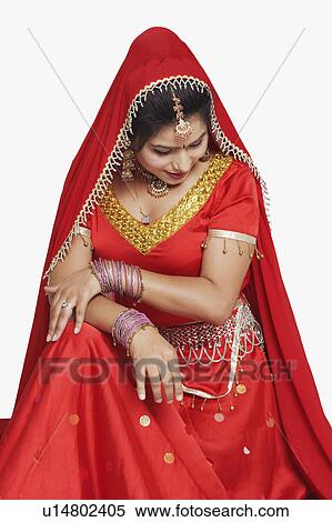 Stock Photography - Close-up of a young woman sitting and looking shy. Fotosearch
