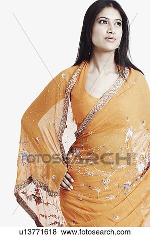 Stock Photo - Close-up of a young woman standing with her hand on her hip. Fotosearch