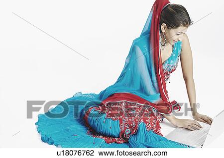 High angle view of a young woman using a laptop View Large Photo Image Stock Image - High angle view of a young woman using a laptop. Fotosearch