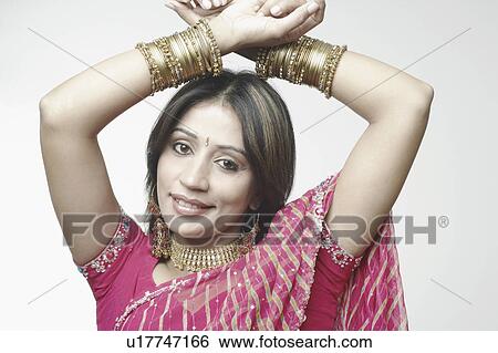 Stock Photograph - Portrait of a mid adult woman with her hands above her head. Fotosearch