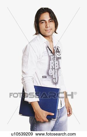 Stock Photo - Portrait of a young man holding a laptop. Fotosearch