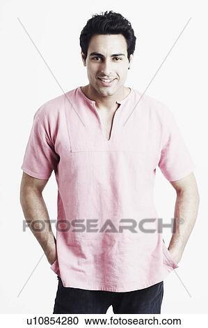 Stock Image - Portrait of a young man smiling with his hands in his pockets. Fotosearch