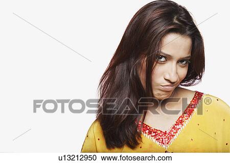 Stock Image - Portrait of a young woman making a face. Fotosearch