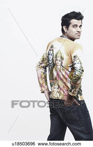 Rear view of a young man standing with his hands in his pockets View Large Photo Image Stock Photograph - Rear view of a young man standing with his hands in his pockets. Fotosearch
