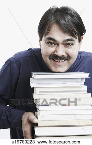Portrait of a businessman holding a stack of books View Large Photo Image Stock Image - Portrait of a businessman holding a stack of books. Fotosearch