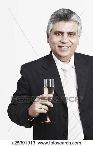 Stock Image - Portrait of a mature man holding a champagne flute. Fotosearch