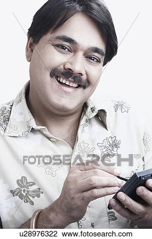 Portrait of a mature man using a personal data assistant View Large Photo Image Stock Image - Portrait of a mature man using a personal data assistant. Fotosearch
