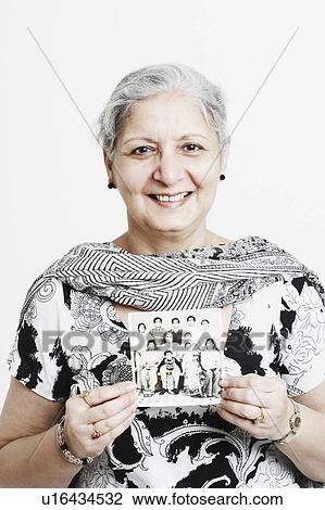 Stock Image - Portrait of a mature woman holding a photograph. Fotosearch